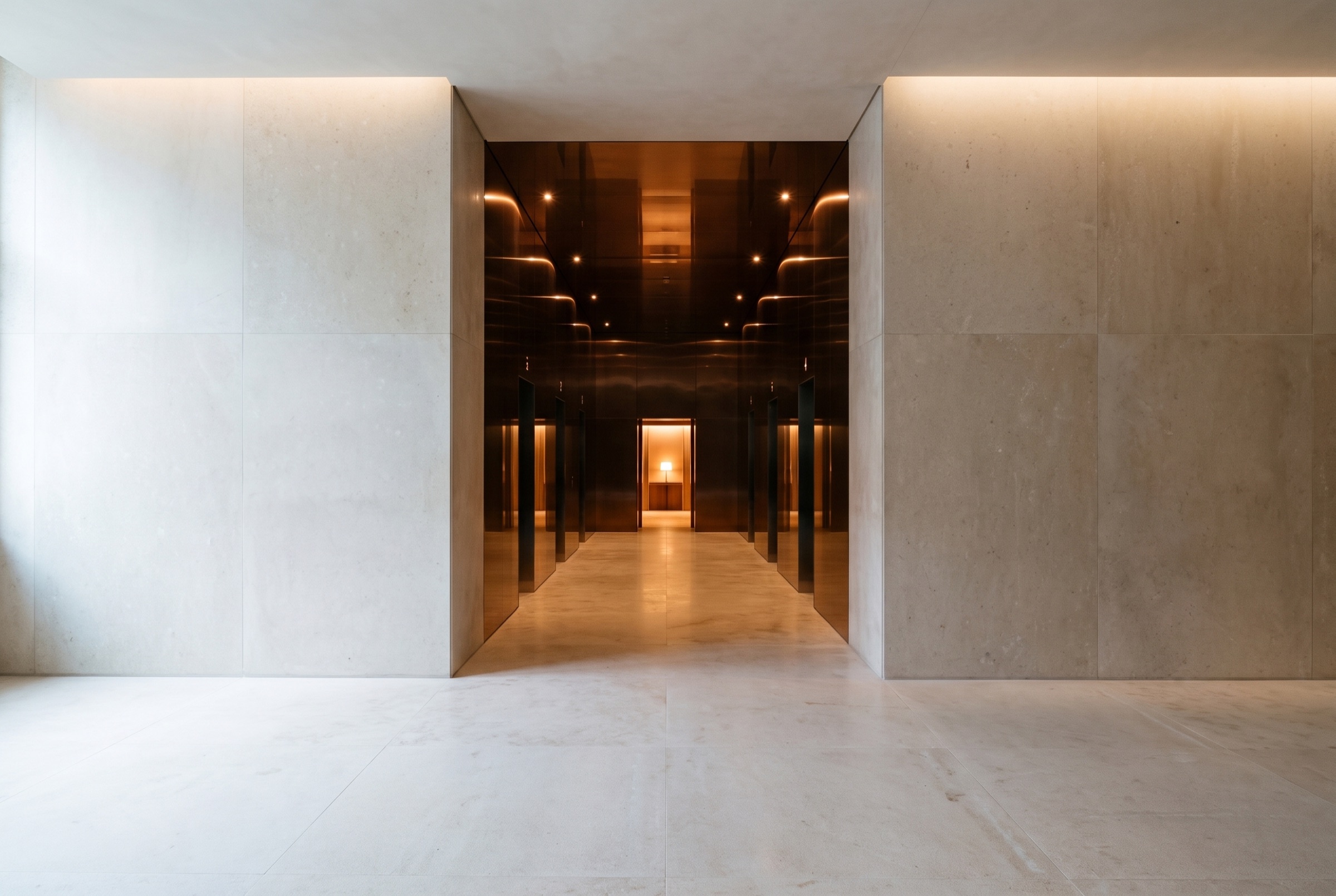 A pale limestone hall opening into a corridor of dark bronze, lit at the far end